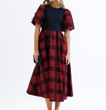 Woman wearing a red and navy checkered dress on a white background